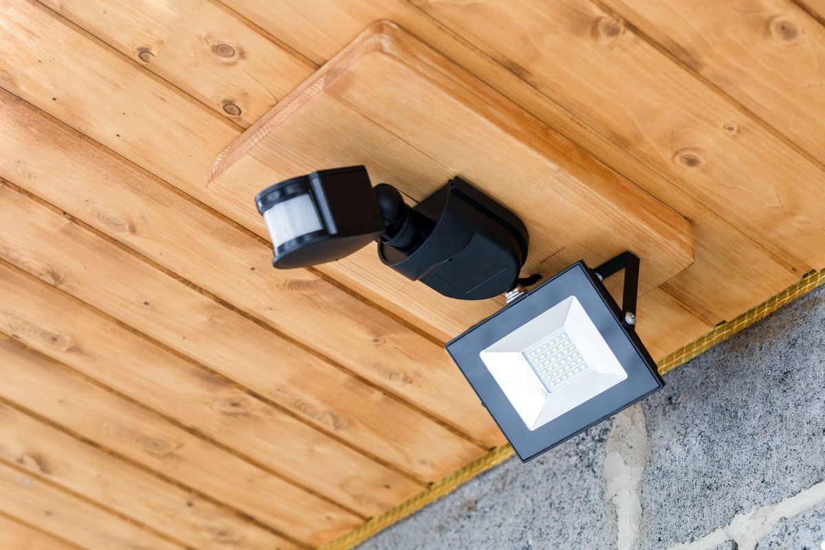 Security light mounted on a wooden wall, providing illumination for safety and visibility in the surrounding area.